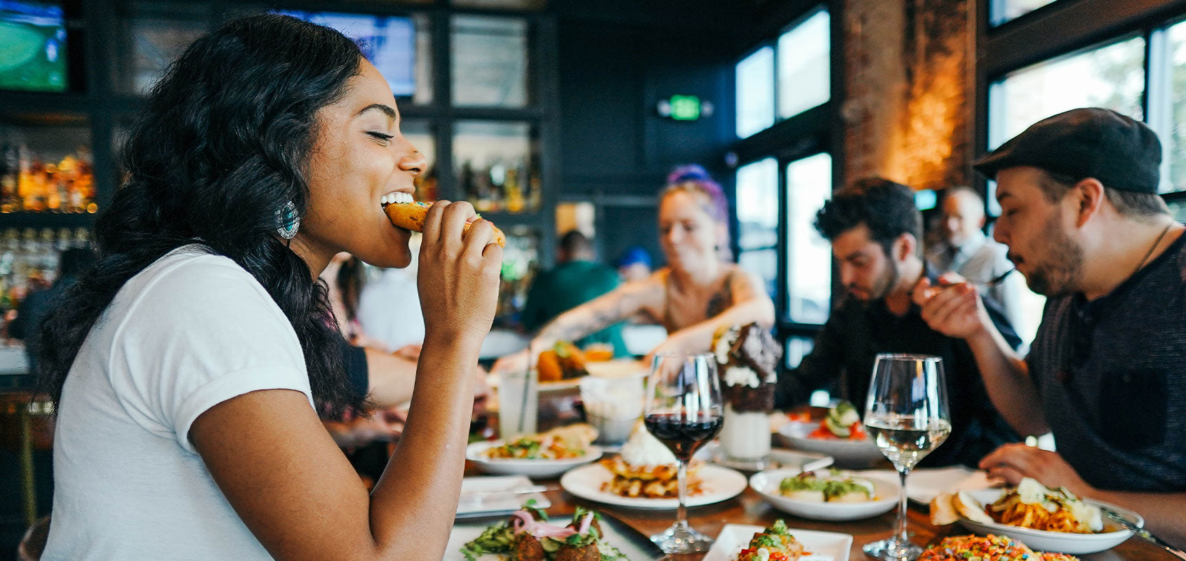 Frau in Restaurant beißt in Essen