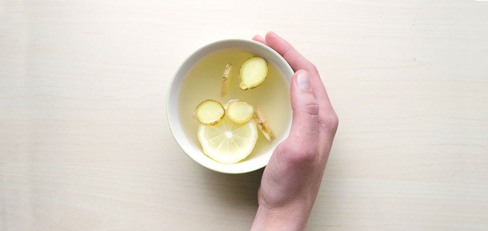 Tasse Tee mit Zitronenscheiben und Ingwer
