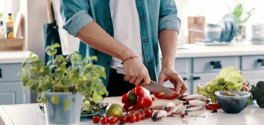 Person schneidet rote Paprika