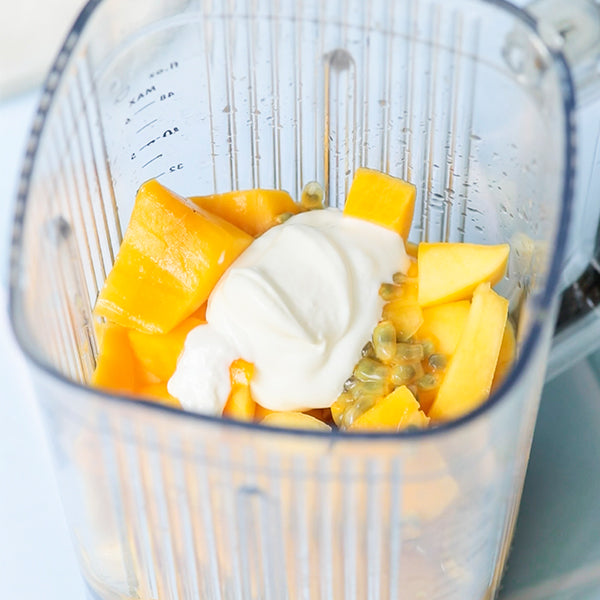 Doe de mango's samen met de overige ingrediënten in een blender